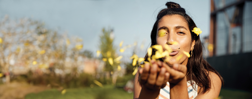 young woman scattering flower pedals